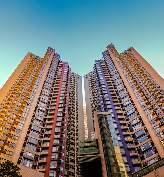 about-04 Tall, colorful skyscrapers reaching into the blue sky in Hong Kong, showcasing modern architecture.