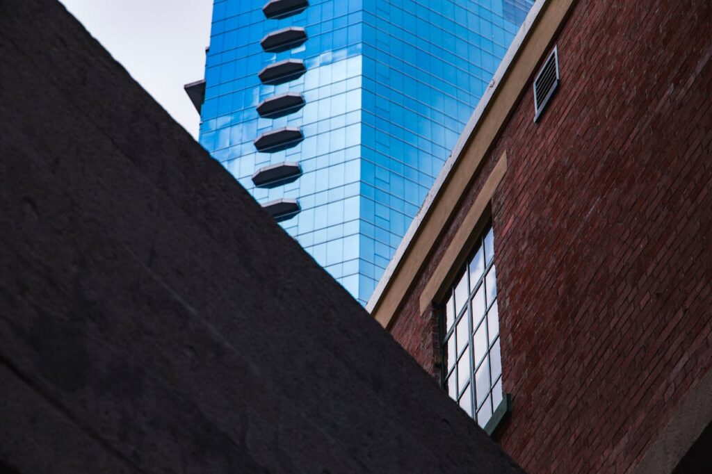 A striking image capturing the contrast between modern glass skyscrapers and traditional brick buildings in Hong Kong.