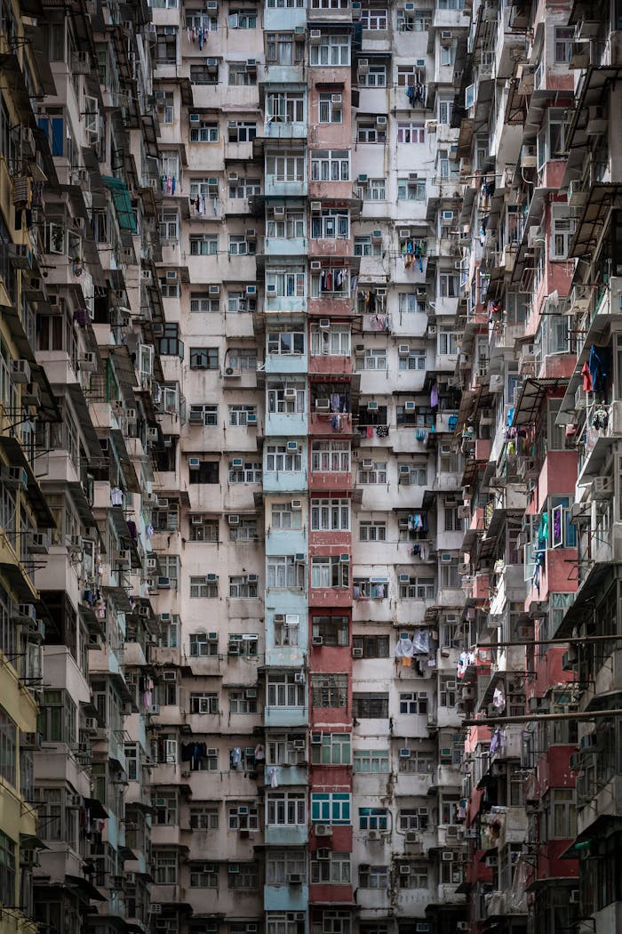 services-02 A dramatic view of crowded, towering apartment buildings in Hong Kong, showcasing urban density.