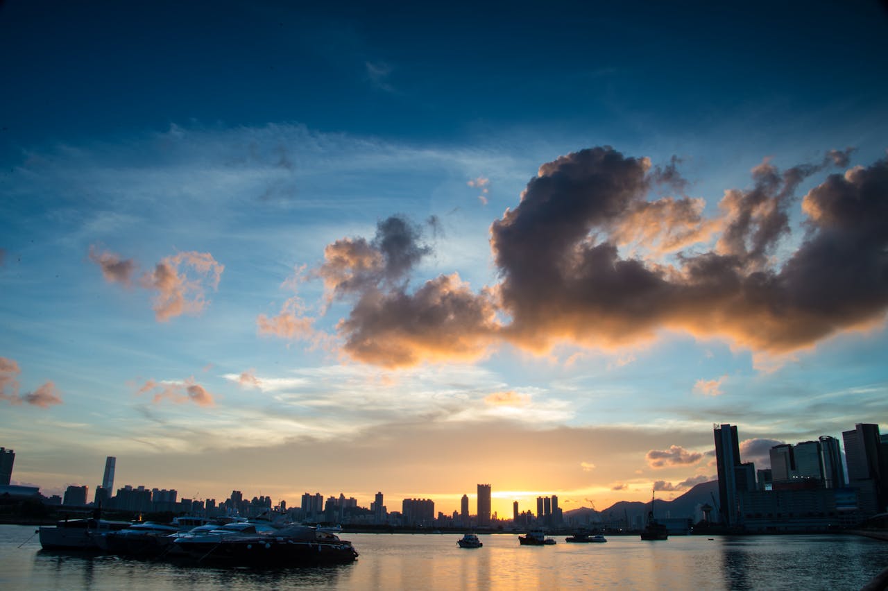 services-03 Spectacular sunset over Kowloon harbor with a dramatic skyline and calm waters.